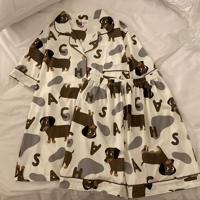 A set of dachshund-themed pajamas laid out on a surface, featuring a shirt with dachshund prints and pants.
