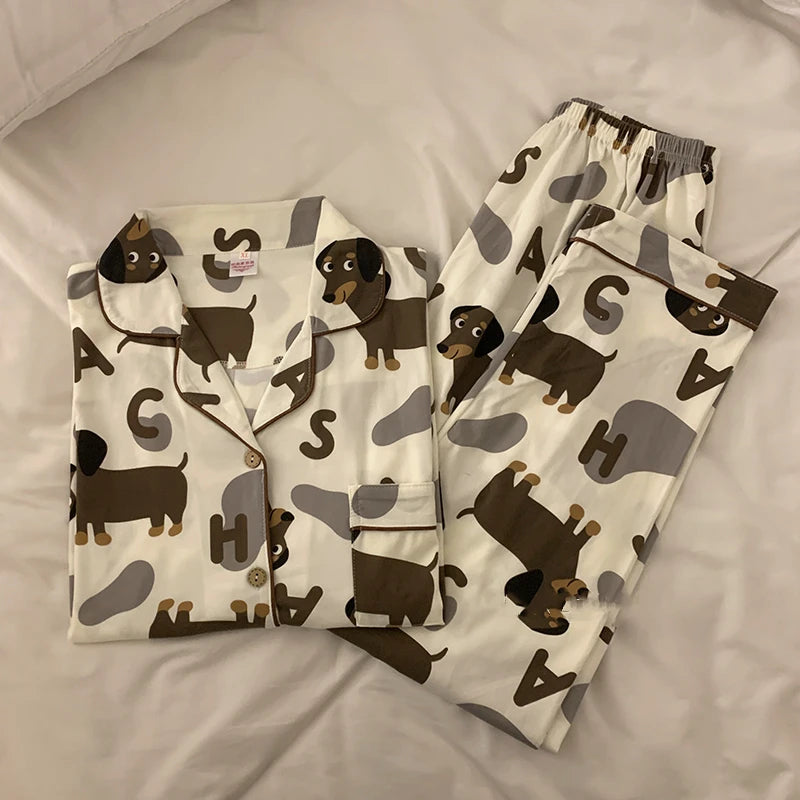 A set of dachshund-themed pajamas laid out on a surface, featuring a shirt with dachshund prints and pants.