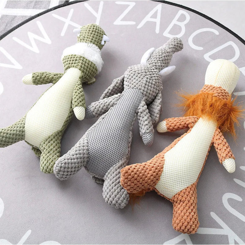 Three knitted dolls in green, gray, and orange on a surface with letters.