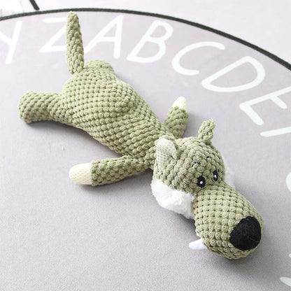 Crocheted dog toy on a light gray surface with a letter board in the background