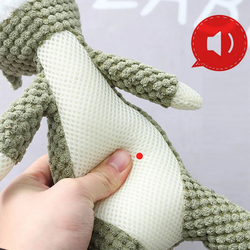 Hand holding a green knitted toy with a white textured center, on a light gray background.