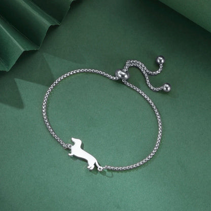 Silver bracelet with a dachshund charm on a green background