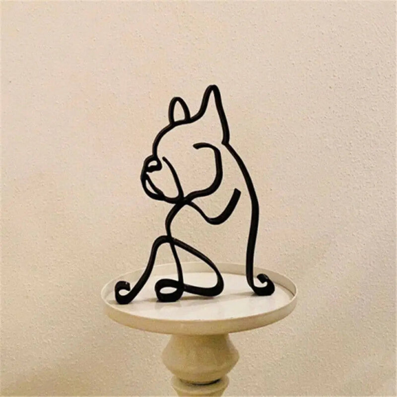 Black wire sculpture of a dog on a small white pedestal against a beige background