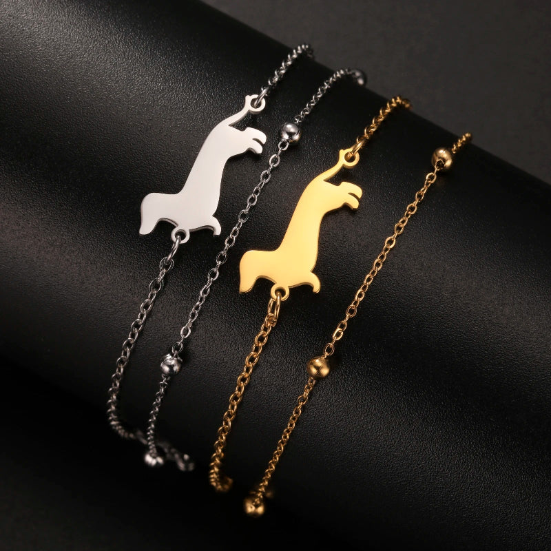 Three necklaces with llama-shaped pendants on a black background