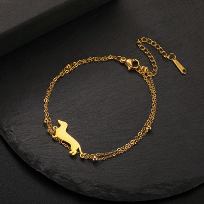 Gold bracelet with a dog silhouette on a dark surface