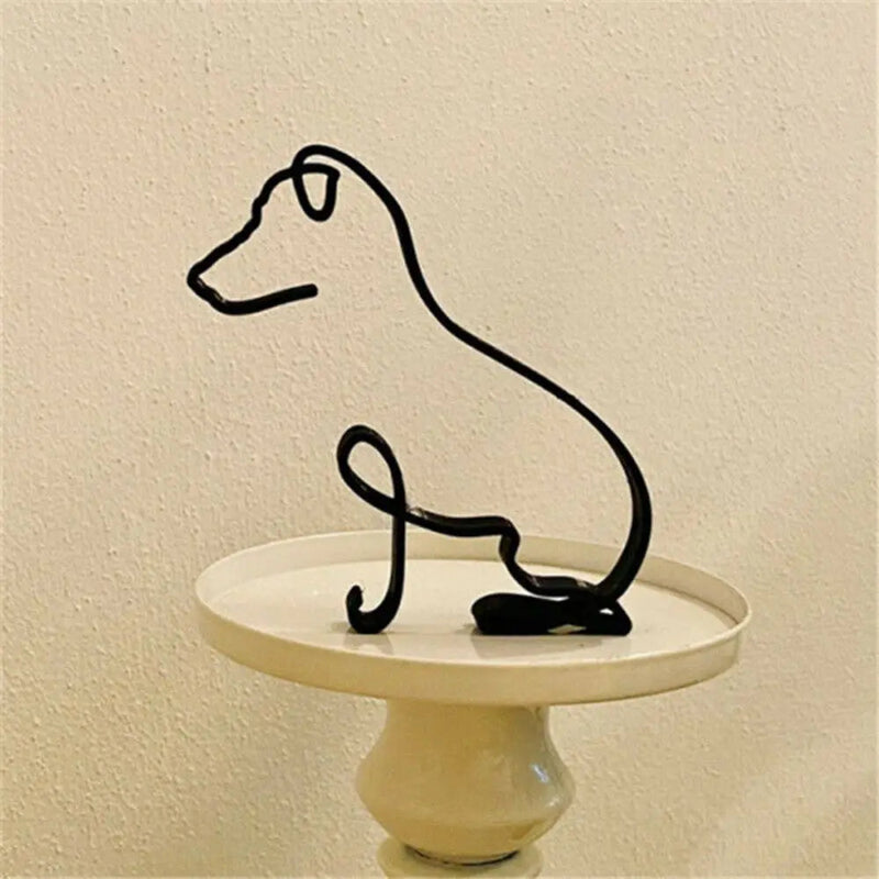 Black wire dog sculpture on a white pedestal against a beige wall