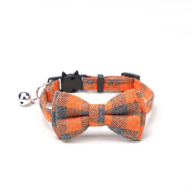 Dog collar with a checkered bow tie and bell on a white background