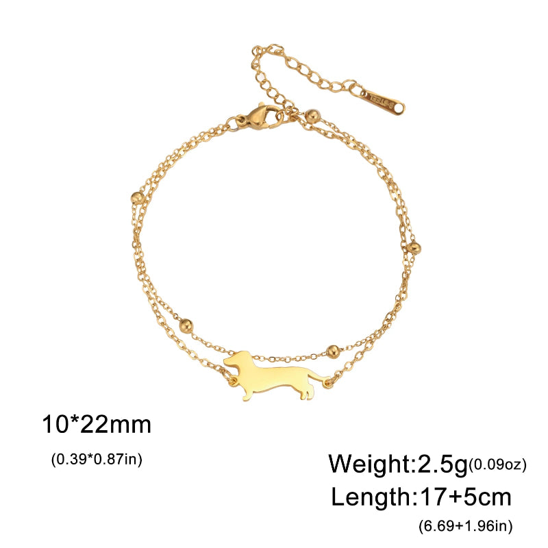Gold bracelet with a dog-shaped charm on a white background