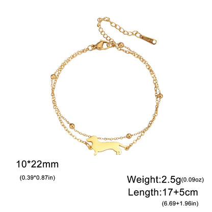 Gold bracelet with a dog-shaped charm on a white background
