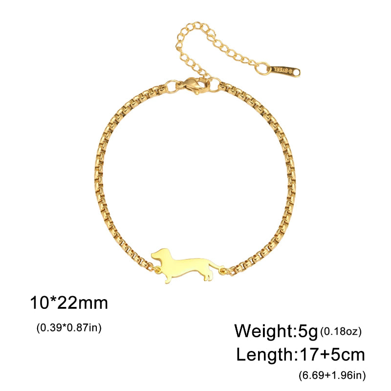 Gold bracelet with a dog-shaped charm on a white background