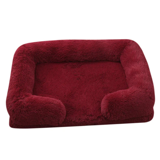 A plush red winter pet bed with raised edges and a non-slip base.