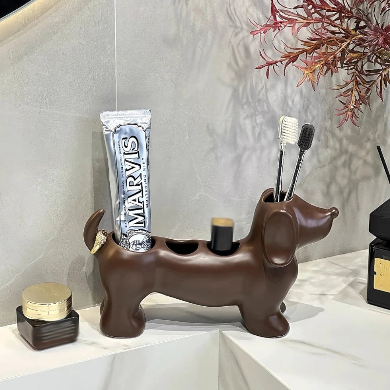 Dog-shaped toothbrush holder with Marvis toothpaste and brushes on a light surface.