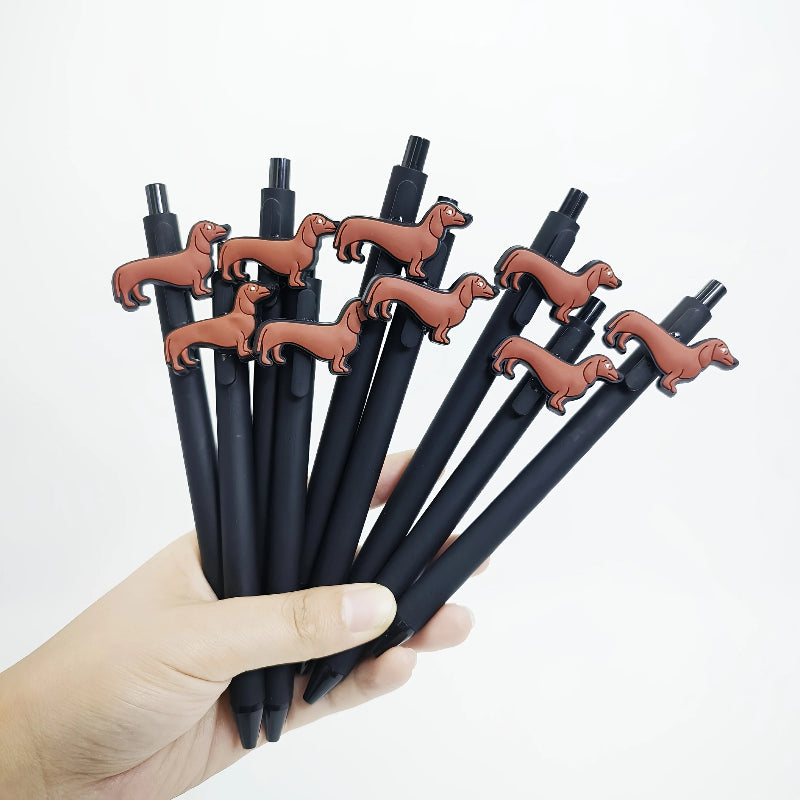 Black pens with dachshund-shaped clips held by a hand against a white background