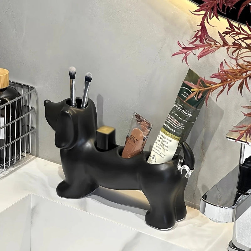 Black dog-shaped makeup brush holder on a bathroom counter with brushes and products.