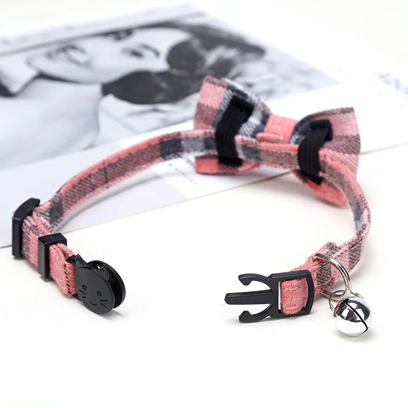 Pink plaid pet collar with a bow tie and bell on a white background